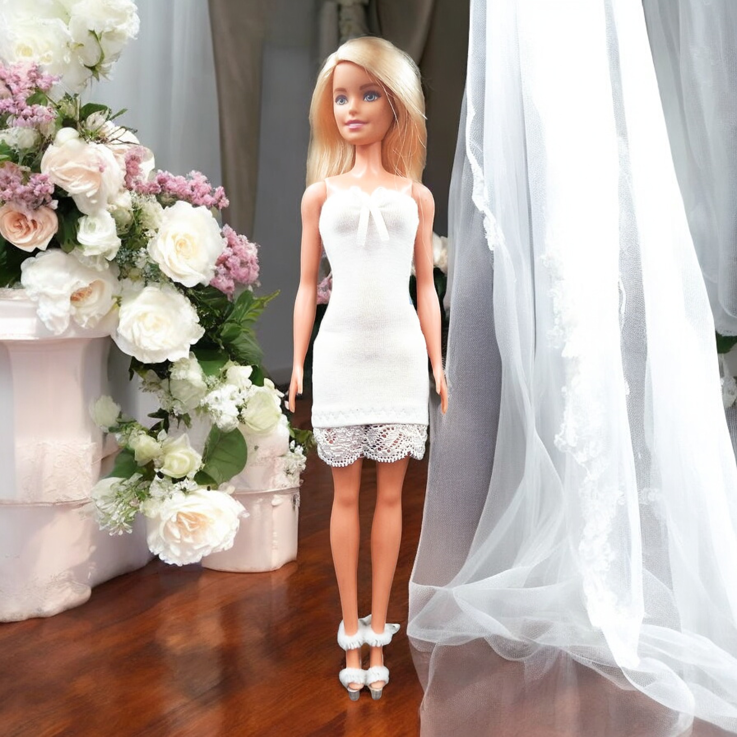 Fehér csipkés barbie ruha előlnézet, virágos háttér
